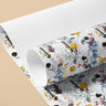 Roll of Wildflower Wonderland contact paper with blue foliage, yellow and coral wildflowers on white, partly unrolled against a tan backdrop