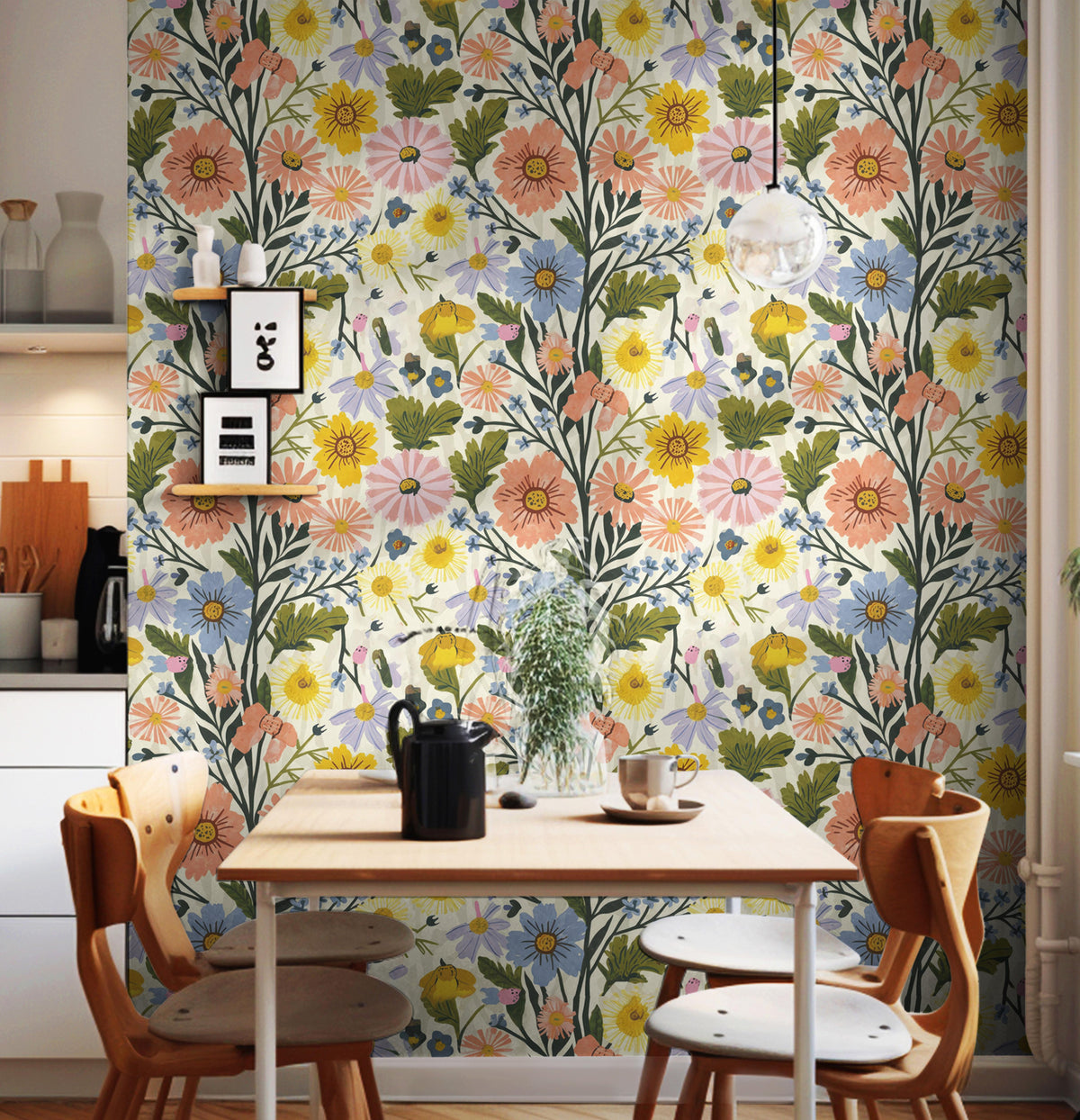 Floral Spring Vibes wildflower wallpaper in coral, yellow, blue and lavender on a dining nook wall with a wooden table and orange chairs