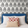 Black Modern 1162 wallpaper featuring a bold black and white geometric peacock feather pattern, styled in a contemporary bedroom with a blue upholstered headboard, white bedding, and decorative accent pillows.