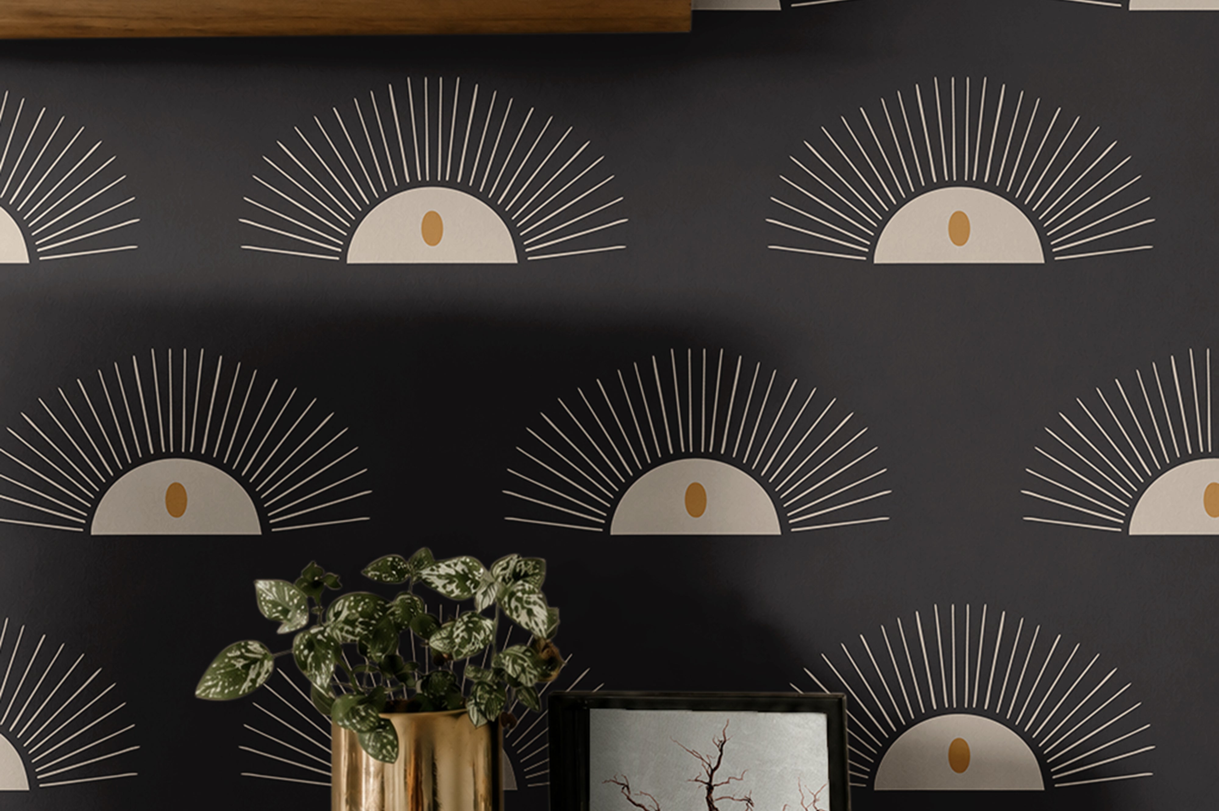 Boho Sunburst 204 black geometric wallpaper with cream sunburst motifs and warm gold accents styled above a modern wood console