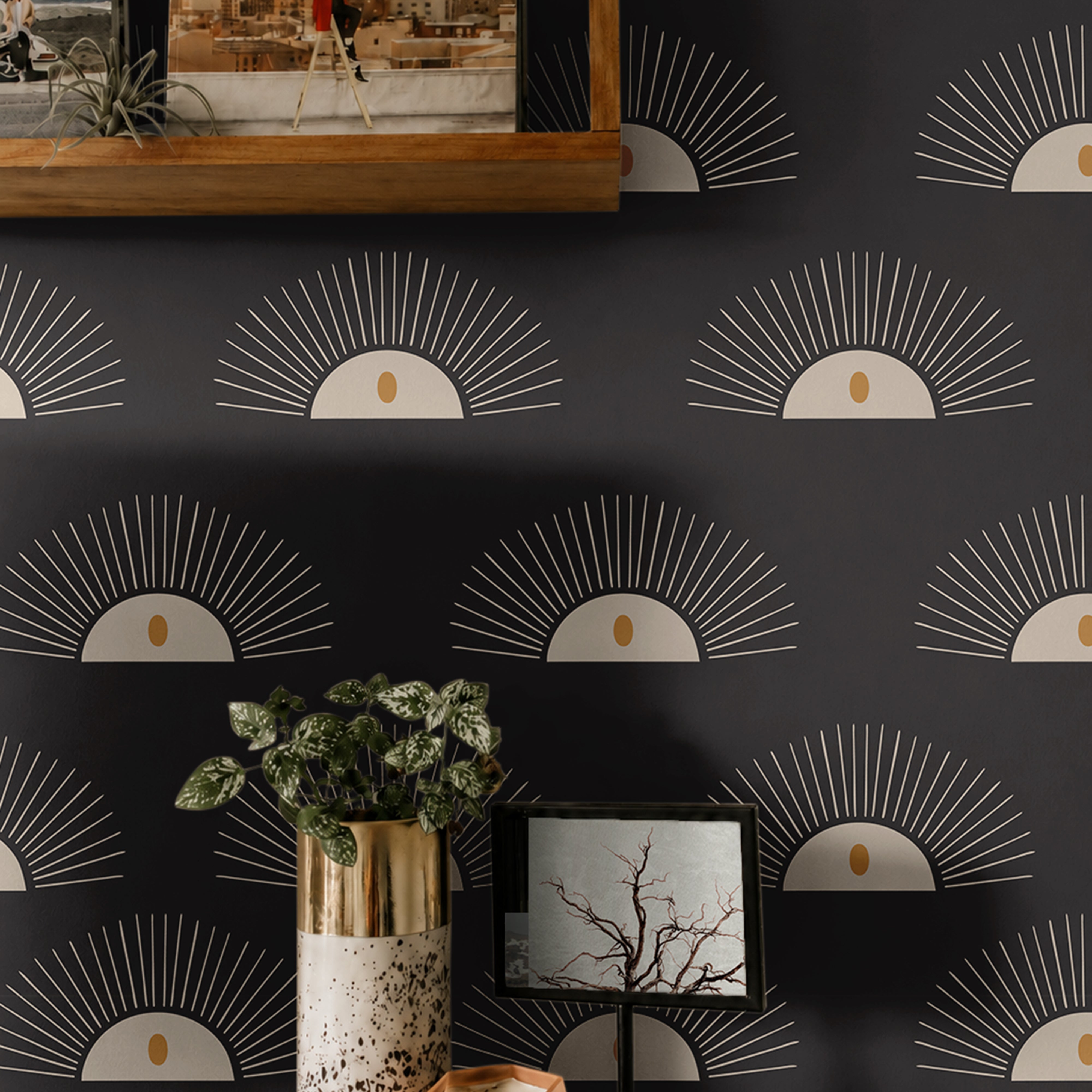 Boho Sunburst 204 black geometric wallpaper with cream sunburst motifs and warm gold accents styled above a modern wood console