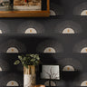 Boho Sunburst 204 black geometric wallpaper with cream sunburst motifs and warm gold accents styled above a modern wood console