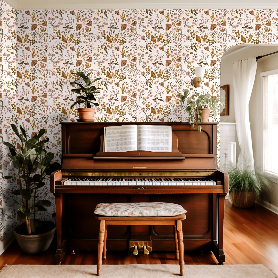 Interior wall styled with Brassmere Wilds wallpaper showing wildflowers, butterflies, and botanical stems across a warm ivory background.
