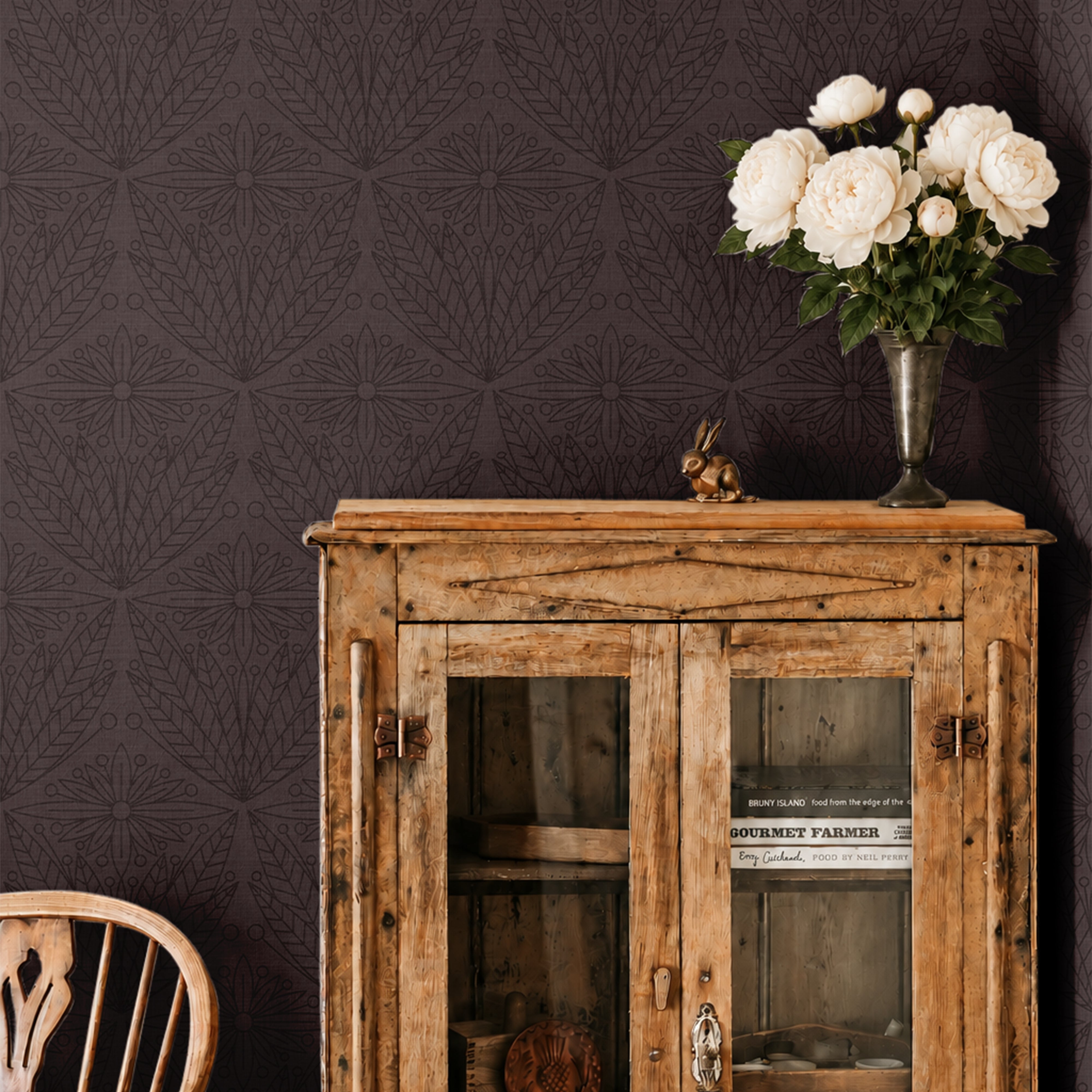 cabernet and gentry 3550 burgundy botanical wallpaper behind rustic wood cabinet with white roses in a vase and wood chair