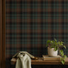 dark green charcoal and russet plaid wallpaper behind wood shelf with books, plants and cloth