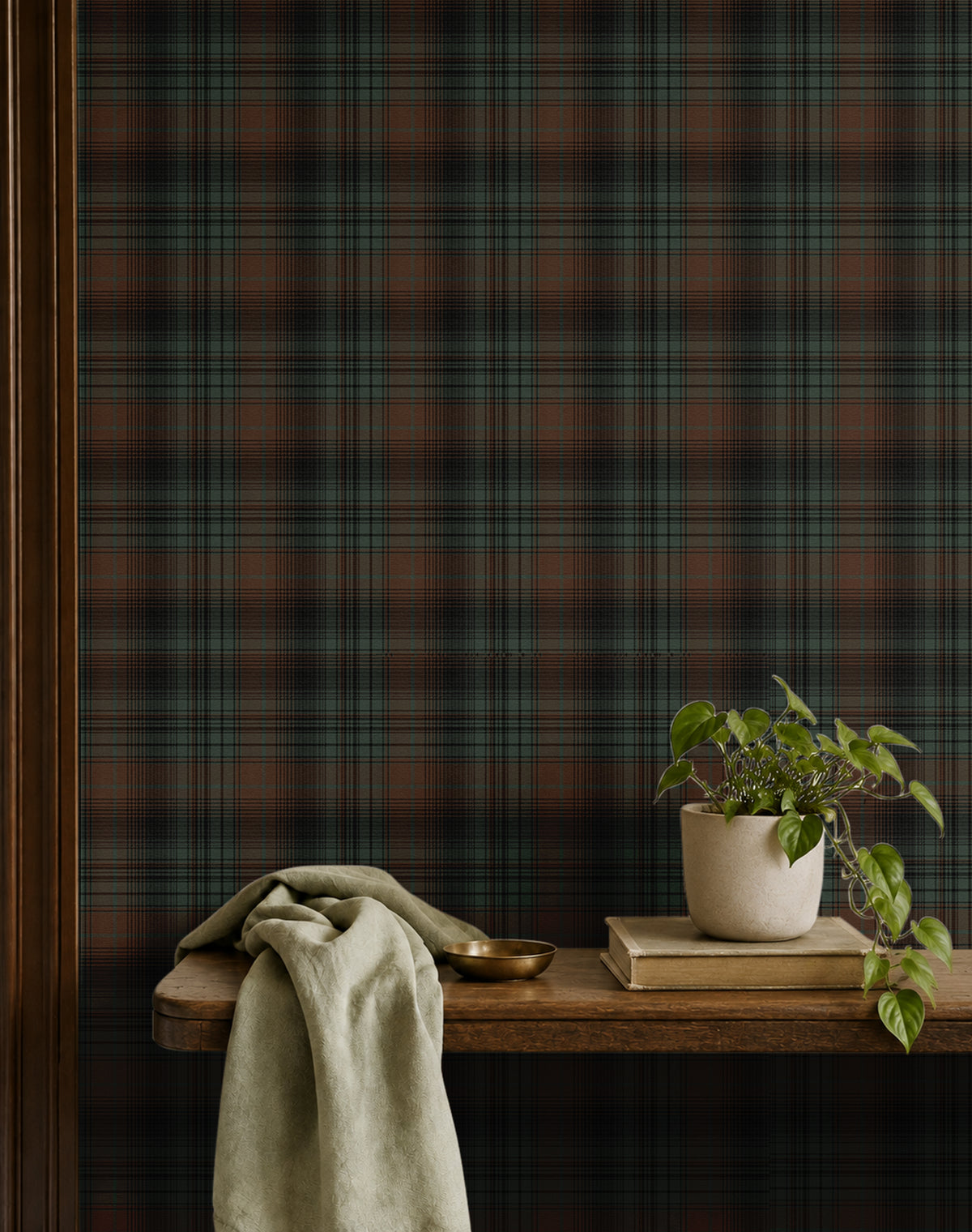 dark green charcoal and russet plaid wallpaper behind wood shelf with books, plants and cloth