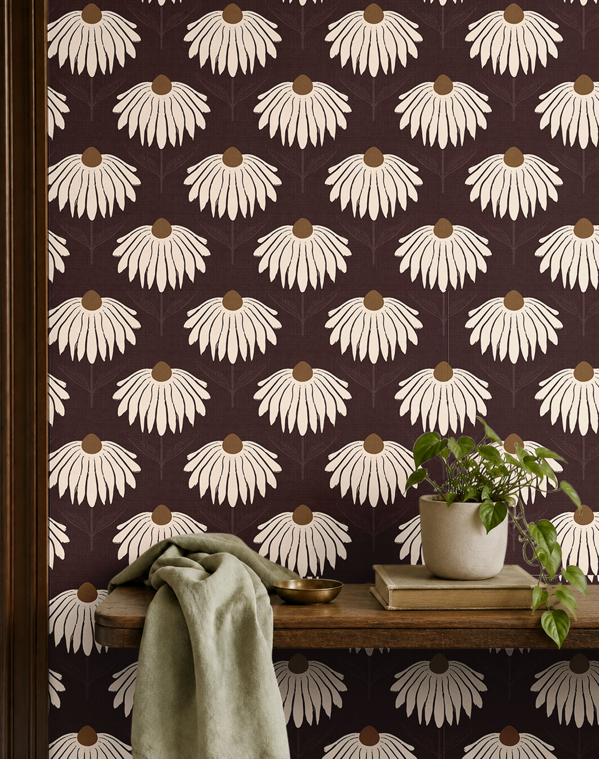 garnet crown 3543 burgundy coneflower wallpaper behind wood shelf with green plant books and sage fabric