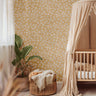 Khaki Flower 147a small floral wallpaper with ivory flowers on a warm khaki background styled in a neutral nursery with a wood crib