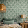 Modern Farmhouse Green 3414 wallpaper with an ivory folk-inspired floral motif on a muted sage green background styled in a cozy bedroom