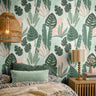 Pink Green Tropical 362 botanical wallpaper with oversized green tropical leaves and soft pink accents styled in a cozy bedroom