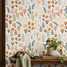 cream floral wallpaper in home office with warm wood shelf with plants books and cloth