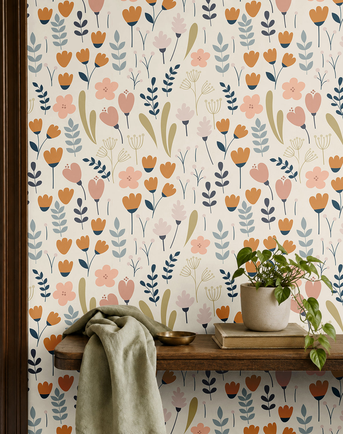 cream floral wallpaper in home office with warm wood shelf with plants books and cloth
