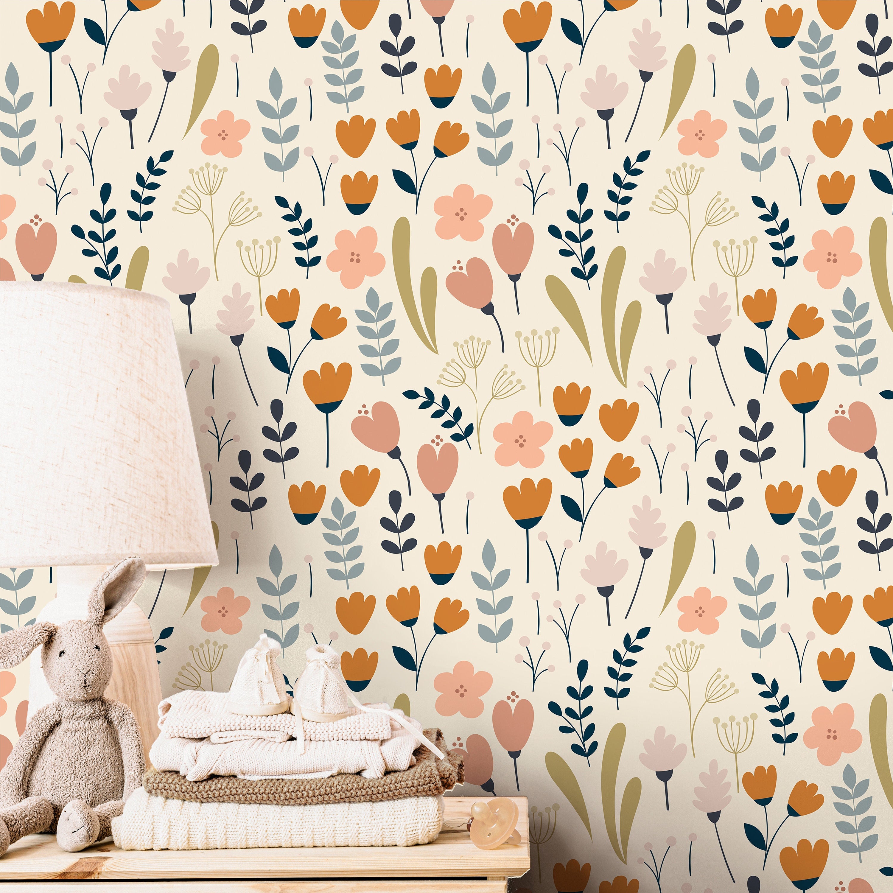cream floral wallpaper in nursery with pale wood crib woven basket peach accents and soft green
textiles