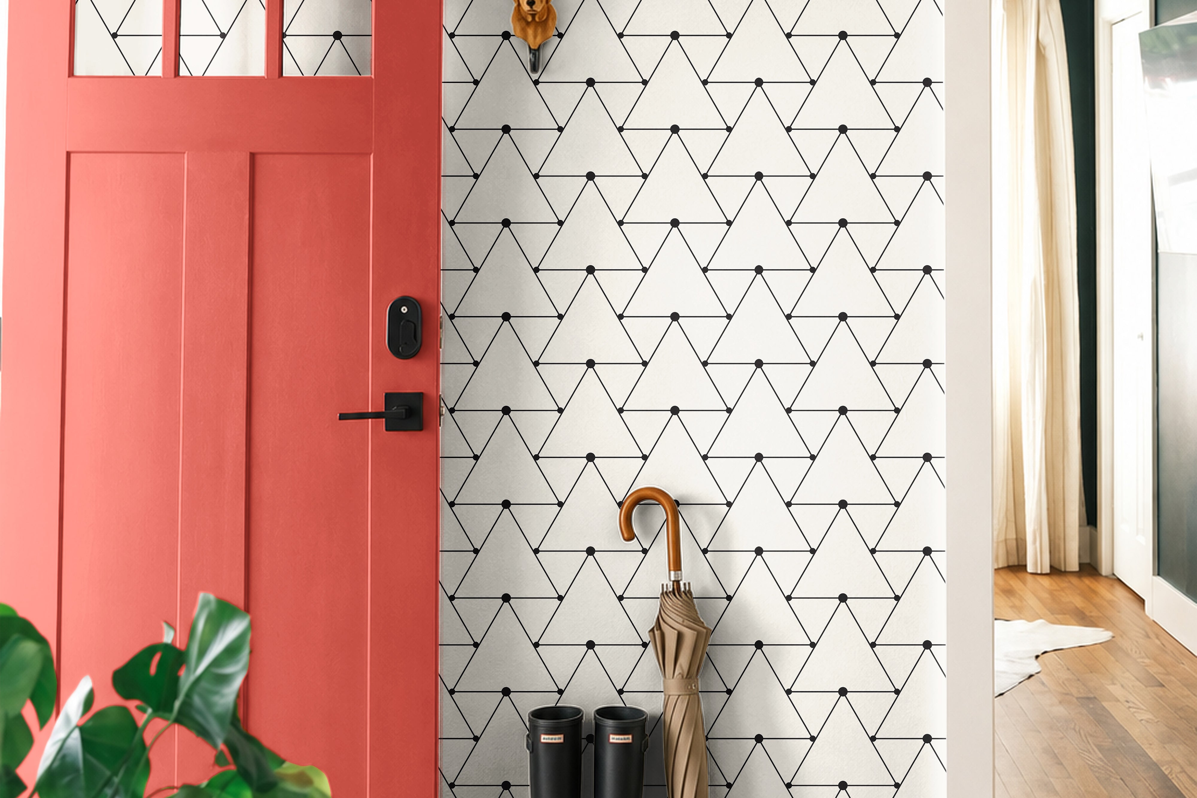 Triangle Geometric 394 wallpaper featuring a repeating black triangle line pattern with small dot accents on a white background, styled in a modern entryway with a coral pink door, natural wood floors, and black rain boots.