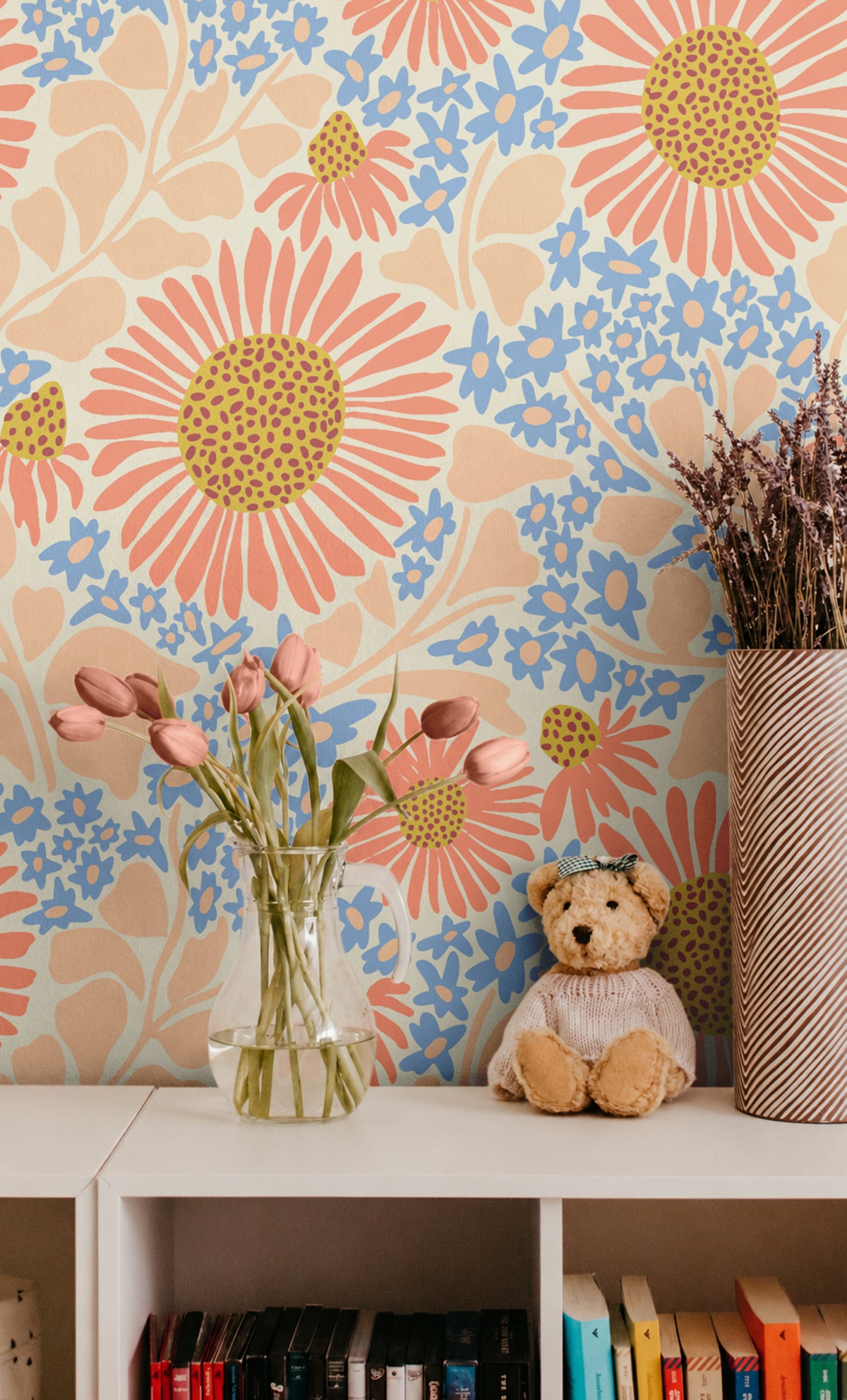 Warm Bloom coral and blue floral wallpaper with oversized wildflowers styled in a cheerful kids room with tulips and teddy bear