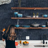 Navy blue abstract line wallpaper behind kitchen open shelving