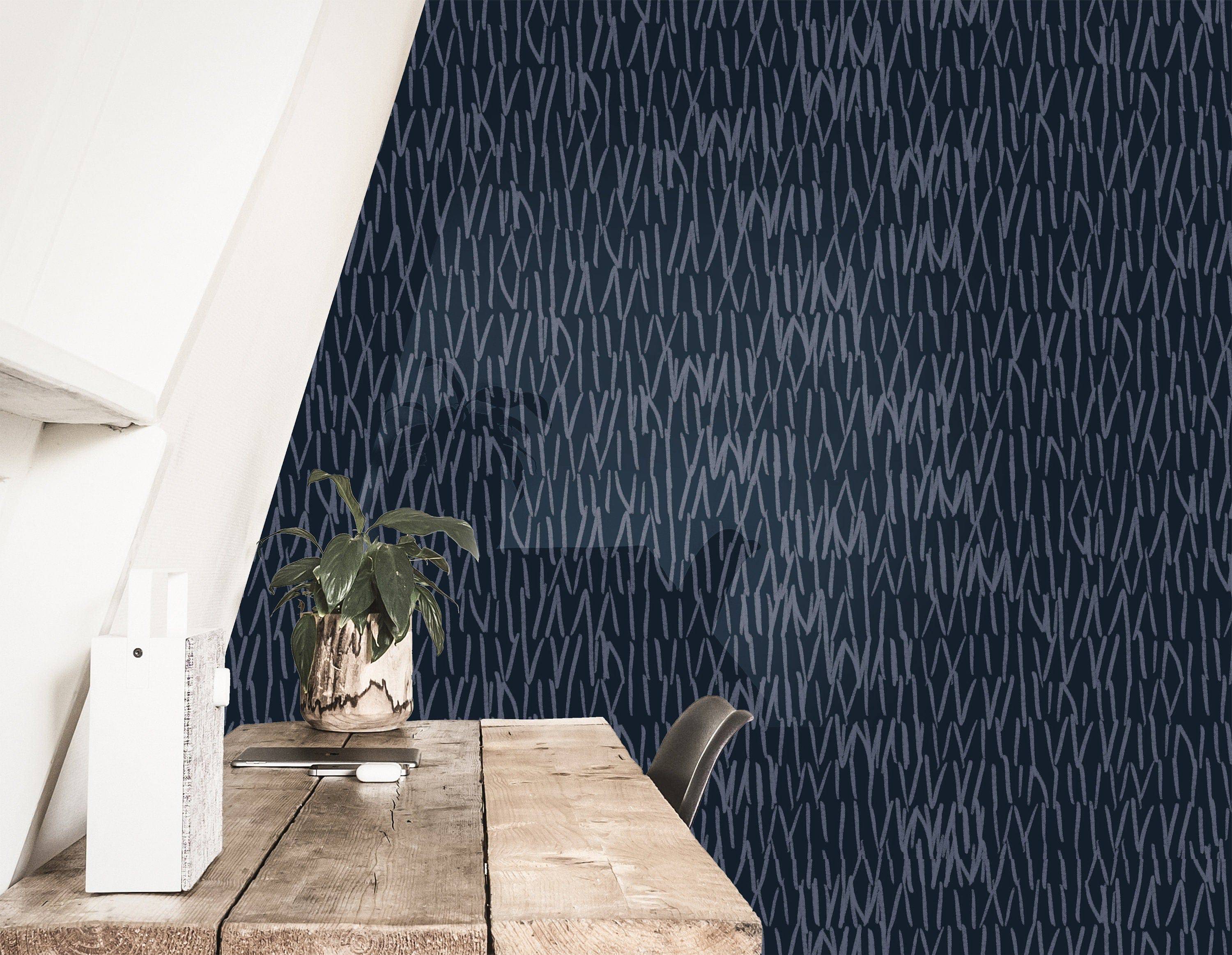 navy abstract line wallpaper behind a rustic wood desk with a potted plant, document holder, and dark chair under a sloped ceiling